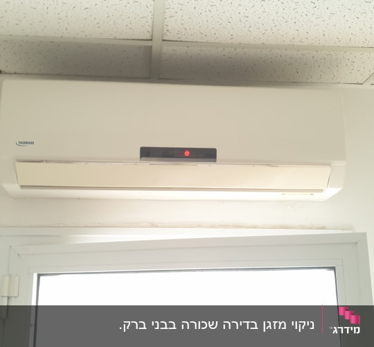 מזגן מותקן על קיר מעל חלון